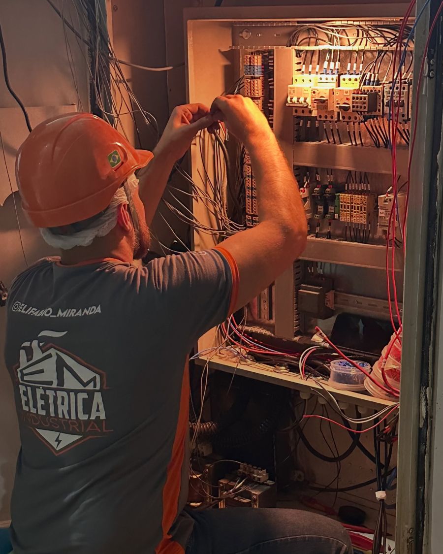 Eletricista da EM Elétrica trabalhando dentro de um painel